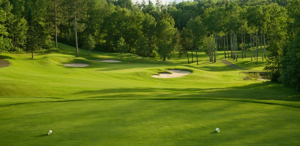 View of golf course green with bunker